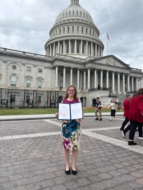 Diana Gelfand holding her 2026 Angels in Adoption certificate in front of the U.S. Capitol
